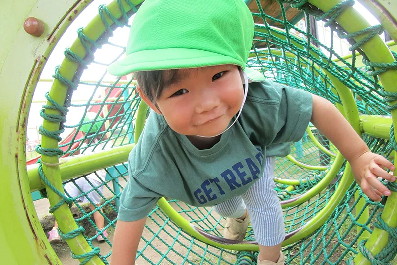 園庭の遊具で遊ぶ子供
